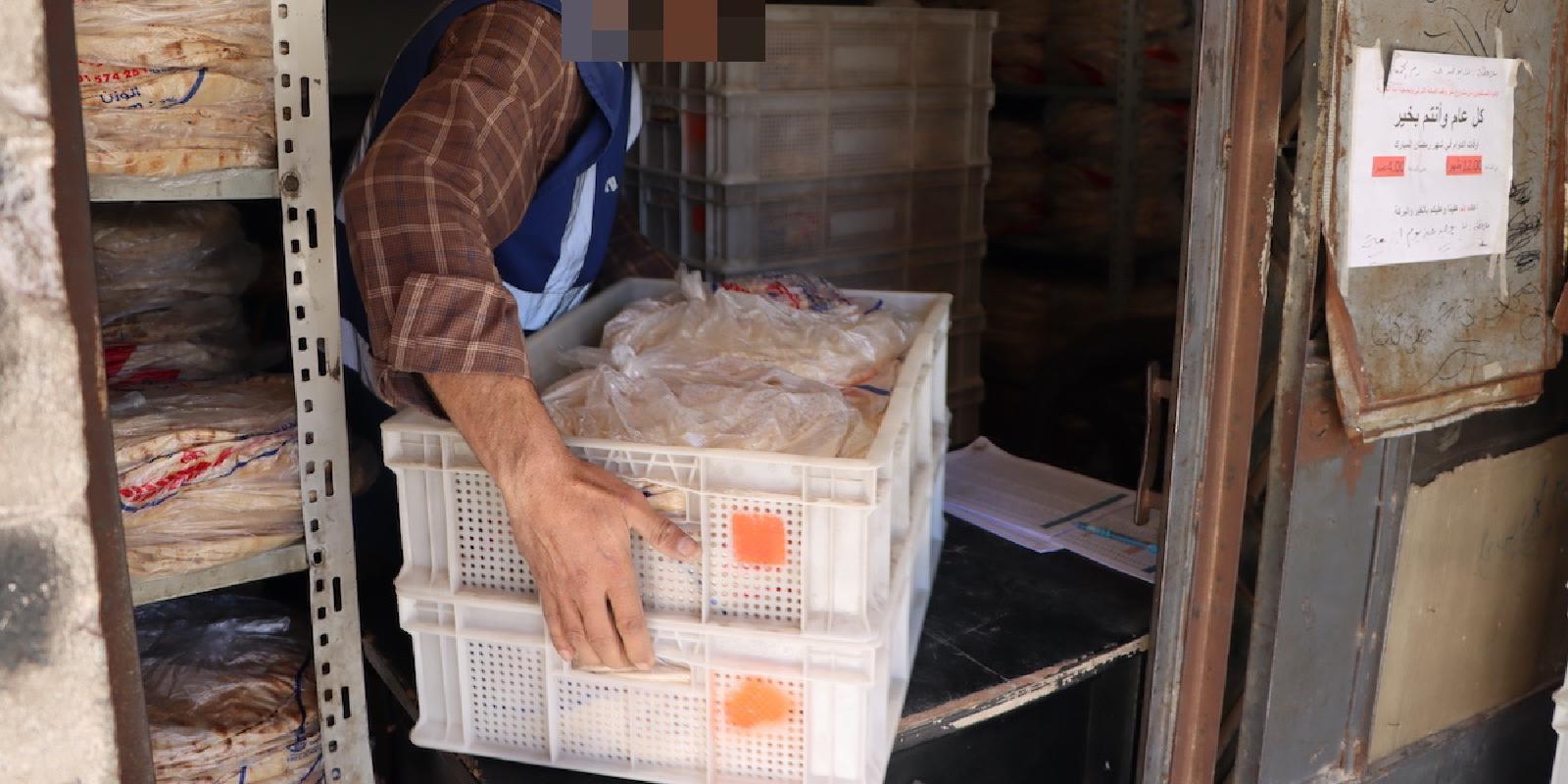 Packs of bread are loaded onto trays, ready for distribution