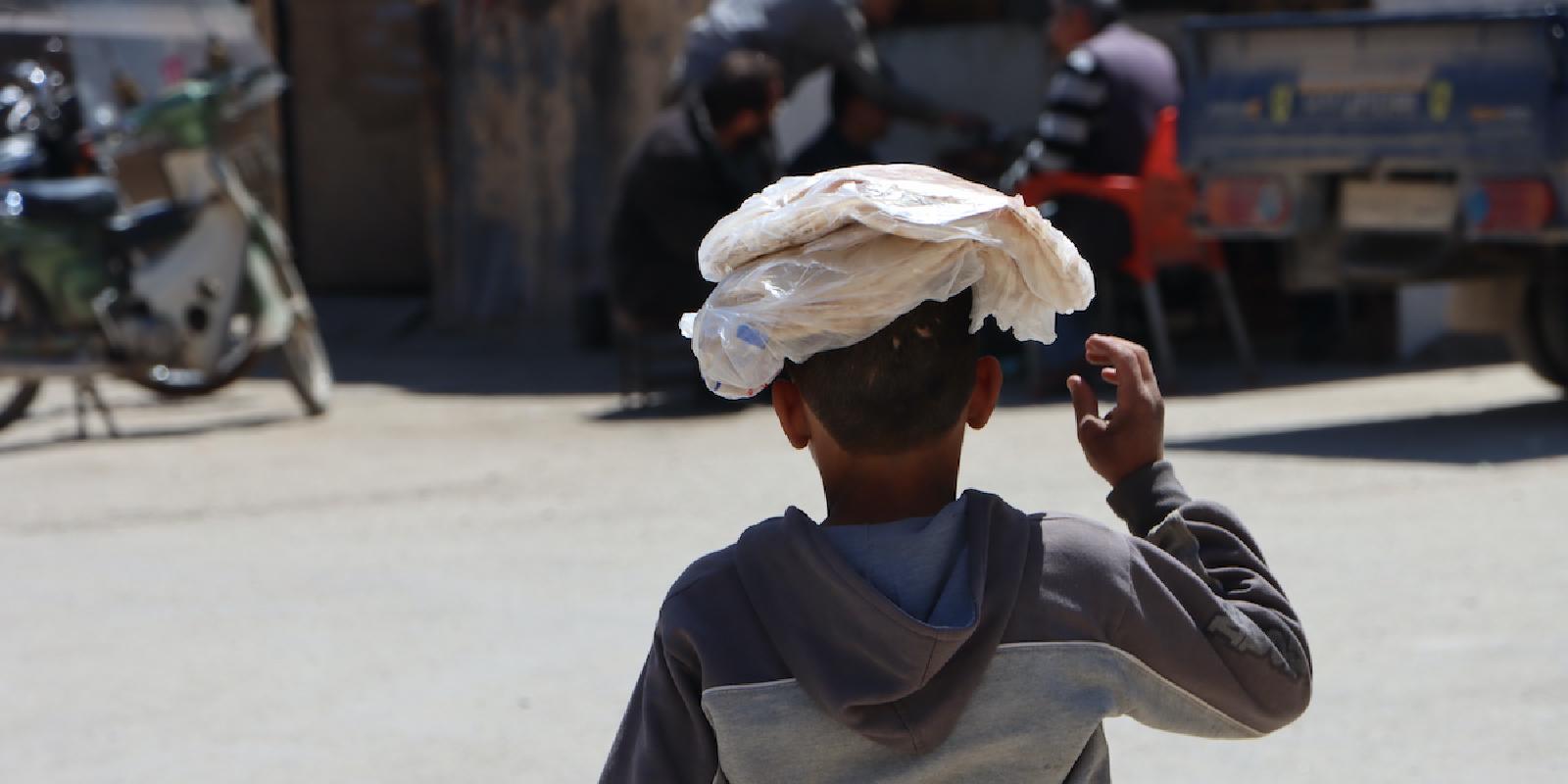 A young boy is given a pack of bread to take home